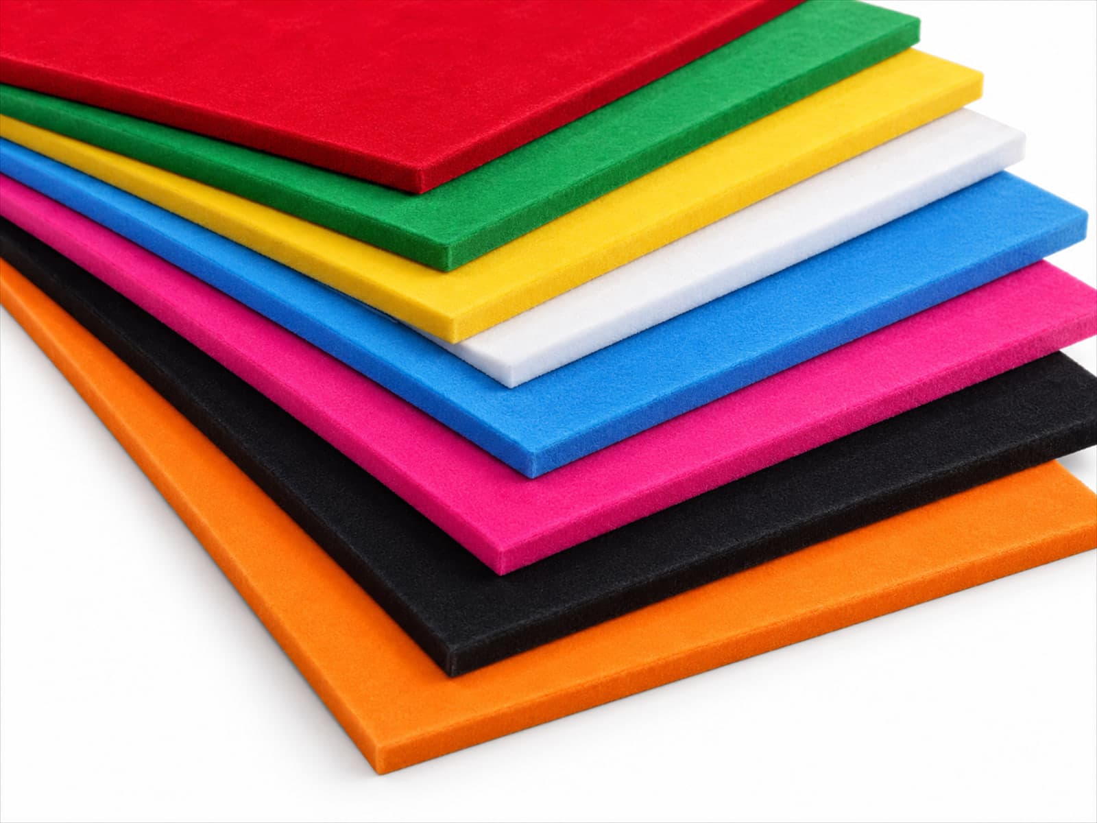 Pilha de chapas plásticas com superfície aveludada em cores variadas, sobre fundo branco
