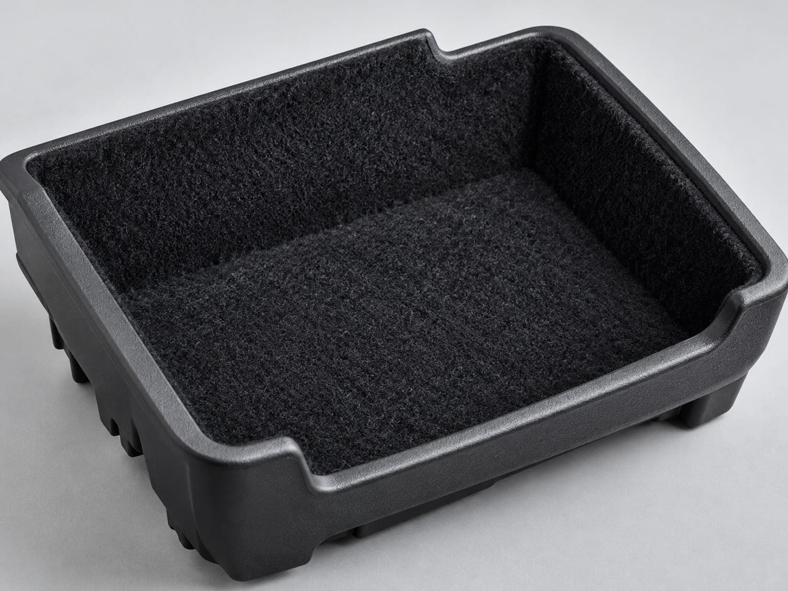 Porta-objetos de plástico preto com interior flocado preto e bordas arredondadas, sobre superfície cinza-clara